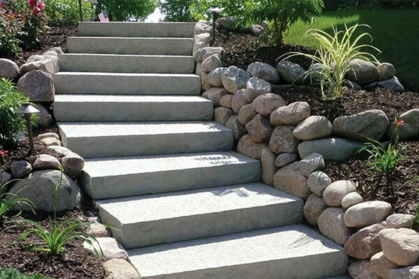 Concrete steps with boulder wall and mulched landscape beds